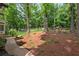 Lush backyard showcasing mature trees, peaceful seating area, and serene wooded surroundings at 5301 Regency Lake Ct, Sugar Hill, GA 30518