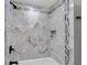Modern bathroom features herringbone tile shower with black fixtures and convenient storage niche at 5301 Regency Lake Ct, Sugar Hill, GA 30518