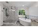 Spa-like bathroom boasts a walk-in shower, soaking tub, and a picturesque outdoor view at 5301 Regency Lake Ct, Sugar Hill, GA 30518