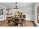Elegant dining room with hardwood floors, large window, and a stylish chandelier above the dining table at 5301 Regency Lake Ct, Sugar Hill, GA 30518
