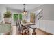 Bright dining room features hardwood floors, statement lighting, and large windows with wooded outdoor views at 5301 Regency Lake Ct, Sugar Hill, GA 30518