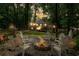 Atmospheric nighttime view of the fire pit area with glowing flames and surrounding trees, great for entertaining at 5301 Regency Lake Ct, Sugar Hill, GA 30518