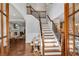 Elegant foyer with hardwood floors, staircase with iron railings, and views into the living spaces at 5301 Regency Lake Ct, Sugar Hill, GA 30518