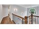 Staircase and hallway featuring hardwood floors, decorative lighting, and natural light at 5301 Regency Lake Ct, Sugar Hill, GA 30518