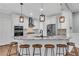 Modern kitchen island featuring granite countertop, a sink, breakfast bar seating and pendant lighting at 5301 Regency Lake Ct, Sugar Hill, GA 30518