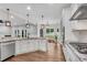 Spacious kitchen with hardwood floors, granite countertops, stainless appliances and an open view to the living area at 5301 Regency Lake Ct, Sugar Hill, GA 30518