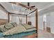 Large main bedroom featuring a tray ceiling, four-poster bed, and an ensuite bathroom at 5301 Regency Lake Ct, Sugar Hill, GA 30518