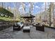 Serene backyard patio featuring comfortable seating beneath a covered area, enhanced by natural surroundings at 6170 Wellington Ct, Cumming, GA 30040