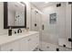 Modern bathroom features white vanity, framed mirror, and glass enclosed shower with tiled walls at 6170 Wellington Ct, Cumming, GA 30040