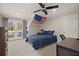 Comfortable bedroom featuring a blue quilt bed, a ceiling fan, and a door to a private balcony at 6170 Wellington Ct, Cumming, GA 30040