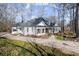 Inviting home with lush landscaping, large trees, a circular driveway, and an American flag at 6170 Wellington Ct, Cumming, GA 30040