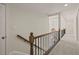 Bright hallway featuring carpet, wood and metal railing, and neutral walls leading to various rooms at 6170 Wellington Ct, Cumming, GA 30040