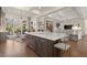 Open concept kitchen with a dark island, views of the living room, and a picturesque backyard at 6170 Wellington Ct, Cumming, GA 30040