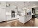 Bright kitchen boasts hardwood floors, white cabinets, stainless steel appliances, and a large center island at 6170 Wellington Ct, Cumming, GA 30040