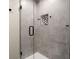Modern shower with glass door, gray tiled walls, and a mosaic-tiled niche for toiletries at 6170 Wellington Ct, Cumming, GA 30040