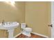A half-bath with a pedestal sink, modern toilet, and neutral walls at 123 Patrick Way, Marietta, GA 30064