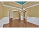 Dining room with tray ceilings, chandelier, wainscotting, and hardwood floors at 123 Patrick Way, Marietta, GA 30064