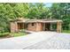Brick home showing spacious driveway leading to a carport with modern wooden accents at 1706 Remington Rd, Atlanta, GA 30341