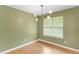 Dining room with hardwood floors, a modern light fixture, neutral green walls, and a window with blinds at 3599 Salem Glen Rd, Lithonia, GA 30038