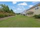 Backyard featuring a well-maintained lawn, a patio area with seating, and mature landscaping at 7190 Tributary Ct, Cumming, GA 30040