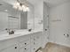 Bright bathroom featuring double sinks, a large mirror, white cabinets, and a walk-in shower at 7190 Tributary Ct, Cumming, GA 30040