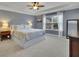 Spacious bedroom with tray ceiling, large window, carpet floors, and wooden furniture at 7190 Tributary Ct, Cumming, GA 30040