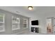 Bright bedroom with natural light, featuring a wall-mounted TV and an adjacent bathroom at 7190 Tributary Ct, Cumming, GA 30040