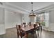 Bright and airy dining room with a wooden table, stylish light fixture, and decorative curtains at 7190 Tributary Ct, Cumming, GA 30040