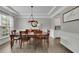 Elegant dining room featuring a wooden table, chandelier, and large window with natural light at 7190 Tributary Ct, Cumming, GA 30040