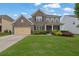 Inviting two-story home with a brick facade, manicured landscaping, and a double-car garage at 7190 Tributary Ct, Cumming, GA 30040