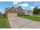 Attractive home featuring a brick facade, a well-maintained lawn, and a spacious driveway at 7190 Tributary Ct, Cumming, GA 30040