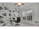 Cozy home office with a decorative dandelion wall, desk, and natural light from the window at 7190 Tributary Ct, Cumming, GA 30040