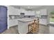 Bright kitchen featuring white cabinetry, stainless steel appliances, granite countertops, and a functional center island at 7190 Tributary Ct, Cumming, GA 30040