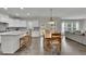 Spacious kitchen with granite countertops, an island with seating, and seamless flow into the adjacent dining and living areas at 7190 Tributary Ct, Cumming, GA 30040