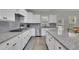 Well-appointed kitchen featuring white cabinetry, stainless steel appliances, granite countertops, and a center island at 7190 Tributary Ct, Cumming, GA 30040