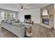 Spacious living room features a stone fireplace, large windows, and plush seating, perfect for relaxation and entertainment at 7190 Tributary Ct, Cumming, GA 30040