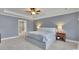 Spacious main bedroom with tray ceilings, carpet floors, and ensuite bathroom access at 7190 Tributary Ct, Cumming, GA 30040