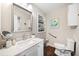Bright bathroom with a vanity, decorative mirror, recessed shelving, and a toilet with a grab bar at 755 Monticello Se Way, Marietta, GA 30067