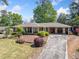 Traditional brick home featuring manicured landscaping, mature plantings, and an attached carport at 755 Monticello Se Way, Marietta, GA 30067
