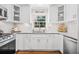 Bright kitchen features white cabinets, granite counters, stainless appliances, and a window over the sink at 755 Monticello Se Way, Marietta, GA 30067