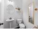 Charming powder room featuring pedestal sink, decorative mirrors and modern toilet at 2022 Talmai Dr, Snellville, GA 30078