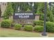 Brookwood Village community sign set amongst lush greenery, showcasing a welcoming entrance at 2022 Talmai Dr, Snellville, GA 30078