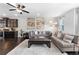 Bright living room featuring hardwood floors, ceiling fan, and dark kitchen cabinets at 2022 Talmai Dr, Snellville, GA 30078