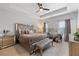 Luxurious main bedroom with tray ceiling, plush bedding, and a stylish seating area at 2022 Talmai Dr, Snellville, GA 30078