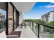Relaxing outdoor balcony features dining set, glass railings and peaceful views of the surrounding trees at 2425 Peachtree Ne Rd # 902, Atlanta, GA 30305
