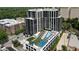 Aerial view of a modern building featuring a pool, tennis court, and green space at 2425 Peachtree Ne Rd # 902, Atlanta, GA 30305