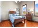 Cozy bedroom features hardwood floors, wooden furniture, and large window at 5097 Peachtree Rd # I, Atlanta, GA 30341