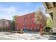 Exterior view of a three-story red brick building with blue doors and landscaping at 5097 Peachtree Rd # I, Atlanta, GA 30341