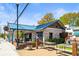 Cozy brick building with a metal roof, outdoor patio with picnic tables, and open sign at 5097 Peachtree Rd # I, Atlanta, GA 30341