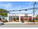 Two-story white brick building with a storefront, picnic tables and red umbrellas for outdoor seating at 5097 Peachtree Rd # I, Atlanta, GA 30341